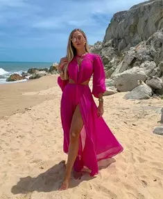 Mulher na praia com vestido longo rosa